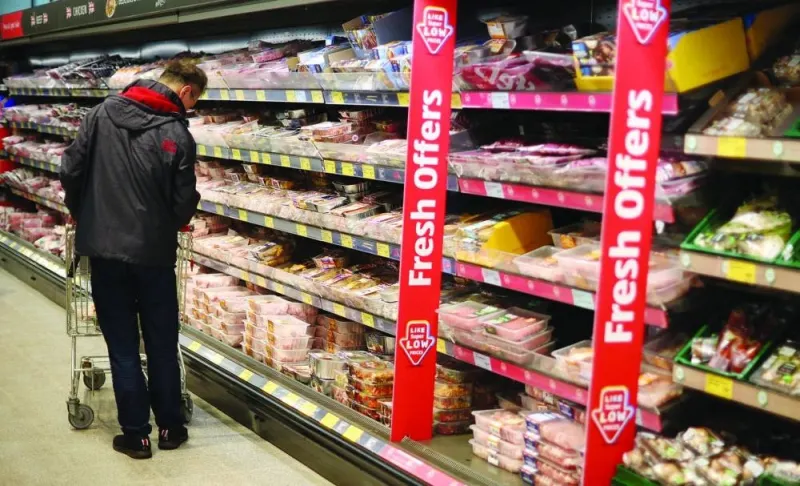 A shopper walks along the meat aisle inside an ALDI supermarket near Altrincham, Britain.