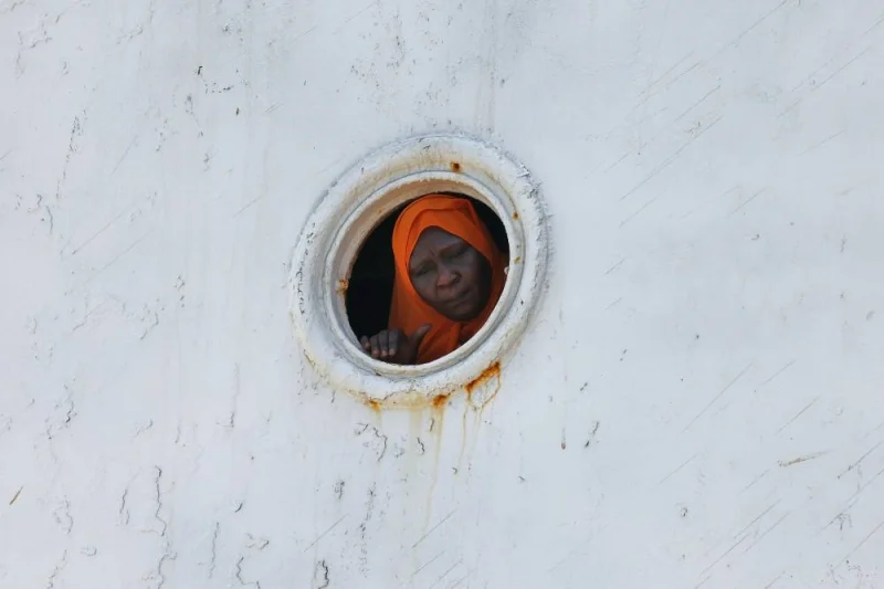 A woman stands a the porthole of a ferry transporting some 1900 evacuees as it docks at the Saudi King Faisal navy base in Jeddah during mass evacuations from Sudan. AFP