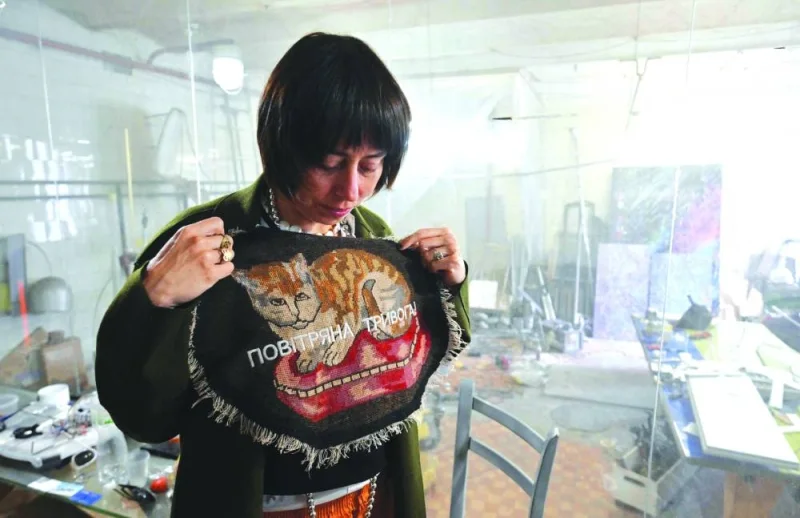 Ukrainian artist Zhanna Kadyrova shows her creation with signing “Air raid alert” in her workshop in Kyiv. (AFP)