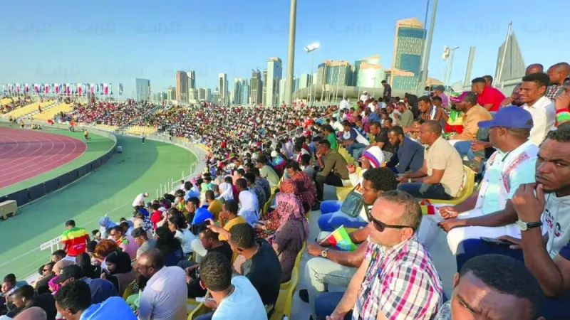 
A packed crowd watches athletes in action. 