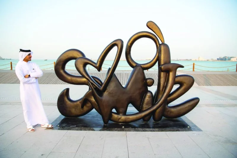  Qatari artist Ahmed al-Maadheed with his artwork &#039;Smile&#039; installed on the Doha Corniche.