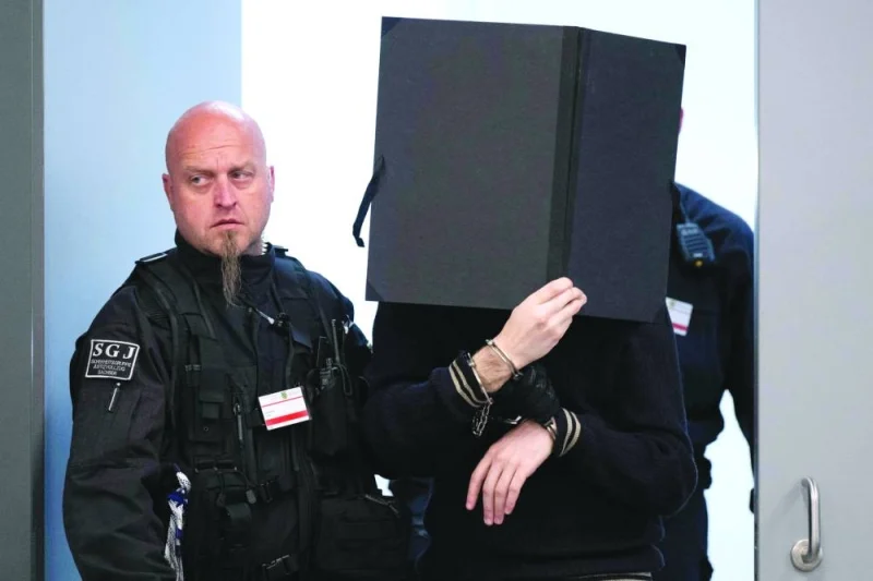 A defendant (right) is brought to the courtroom on Tuesday at the Higher Regional Court in Dresden, eastern Germany, prior to a hearing in the trial. (AFP)
