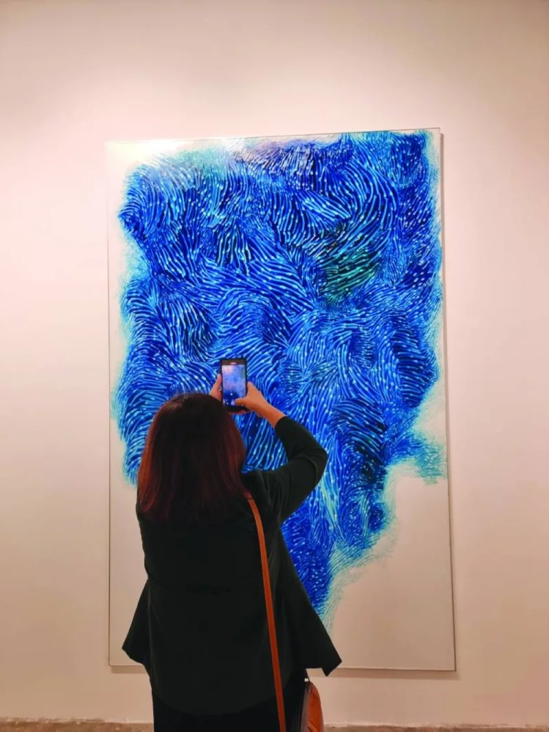 A visitor taking a picture of an artwork by Peter Zimmermann.
