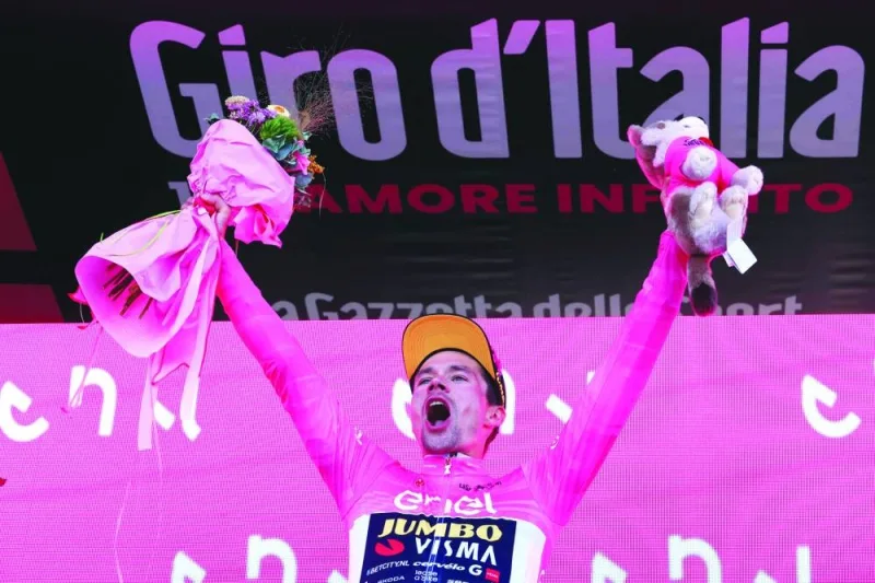 New overall leader Jumbo-Visma&#039;s Slovenian rider Primoz Roglic celebrates his overall leader&#039;s pink jersey on the podium after winning the twentieth stage of the Giro d&#039;Italia, a 18.6 km individual time trial between Tarvisio and Monte Lussari on Saturday. (AFP)