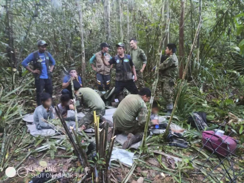 Mmbers of the army assist four indigenous children who were found after spending more than a month lost in the Colombian Amazon jungle following the crash of a small plane on June 9, 2023. AFP PHOTO / Colombian Presidency