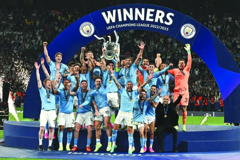 Manchester City players and coach Pep Guardiola celebrate with the trophy after winning the UEFA Champions League at the Ataturk Olympic Stadium in Istanbul on Saturday. (AFP)