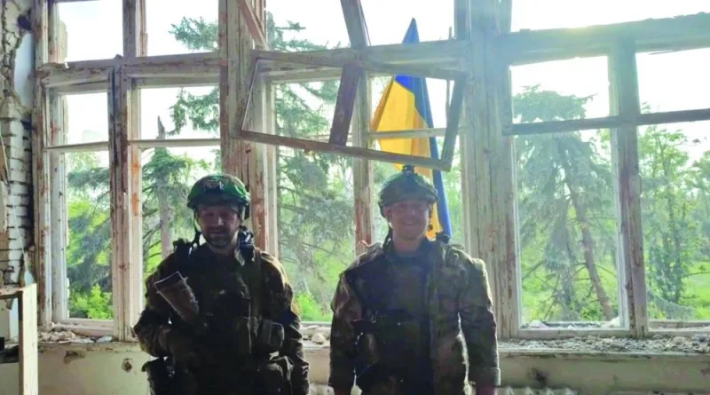 
Ukrainian soldiers stand in front of a Ukrainian flag at a building, during an operation that claims to liberate the first village amid a counter-offensive, in a location given as Blahodatne, Donetsk Region, Ukraine, in this screen grab. (Reuters) 