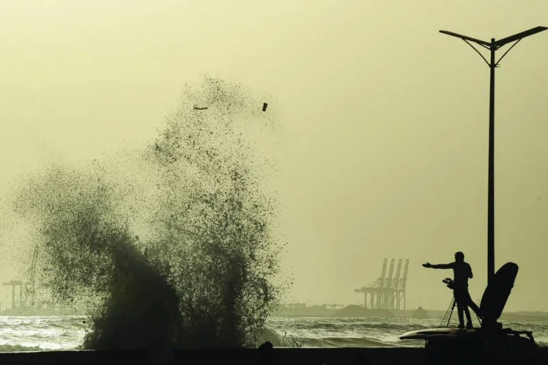 A news cameraman captures high tides at a beach before the onset of cyclone, in Karachi on Monday. AFP)