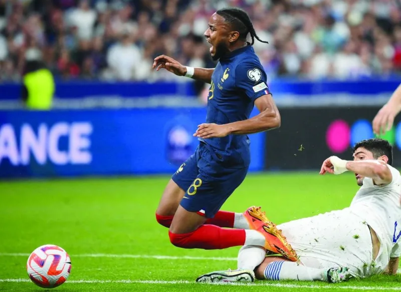 
France’s forward Christopher Nkunku (left) reacts as he is tackled by Greece’s midfielder Dimitrios Kourbelis during the UEFA Euro 2024 Group B qualification match at the Stade de France in Saint-Denis in Paris on Monday. (AFP) 