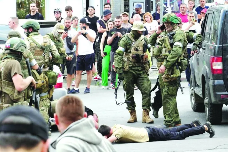 Members of Wagner group detain a man in the city of Rostov-on-Don, Saturday.