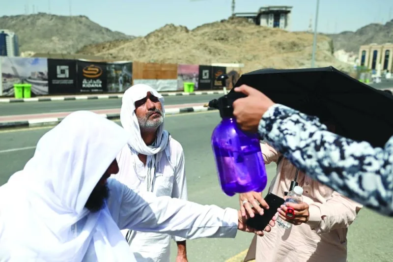 
A member of the Saudi security forces sprays water on Muslim pilgrims during the Haj pilgrimage in Mina, near Makkah. 