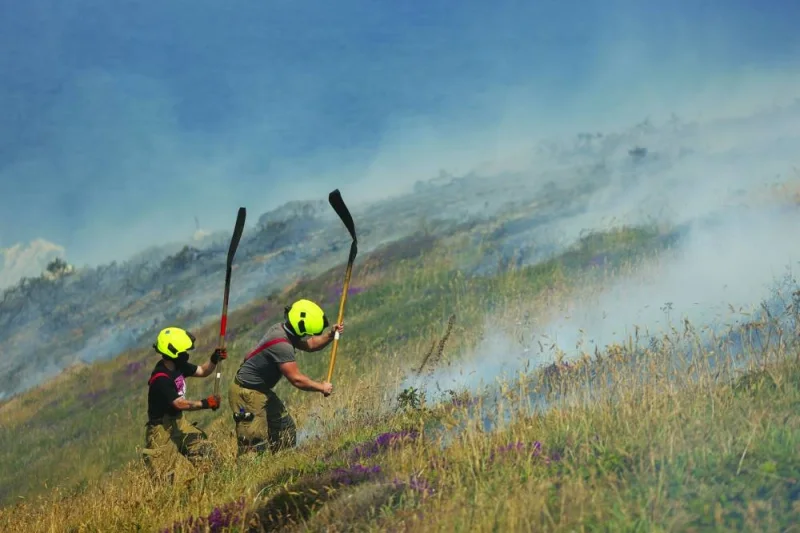 
File photo: Firefighters attend a gorse bush fire, during a heatwave near Zennor, Cornwall, Britain, last July. 