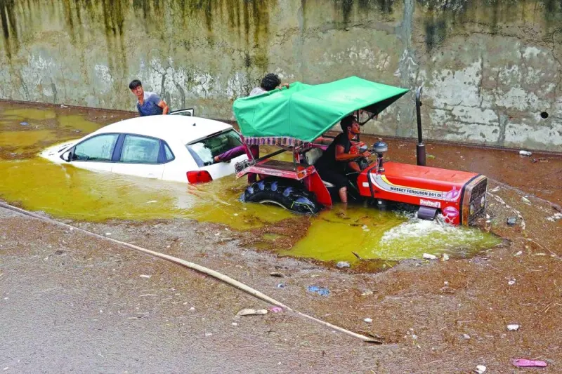 
A tractor tows a deluged car amid a flooded street after heavy monsoon rains in 
Pushkar, in Rajasthan state, yesterday. 