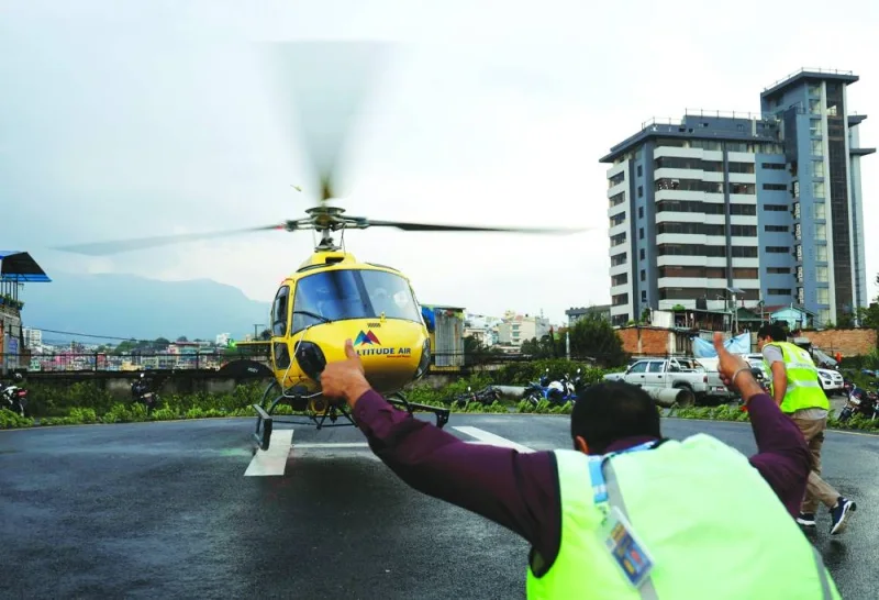 
Officials from Manang air rush towards the helicopter carrying the bodies of victims killed in a helicopter crash, at the Tribhuvan University Teaching Hospital in Kathmandu, Nepal, yesterday. 
