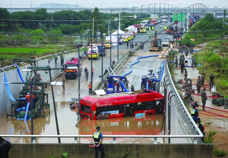 
Rescue workers are seen near a recovered electric bus during a search and rescue operation near an underpass that has been submerged by torrential rain in Cheongju, South Korea, yesterday. 