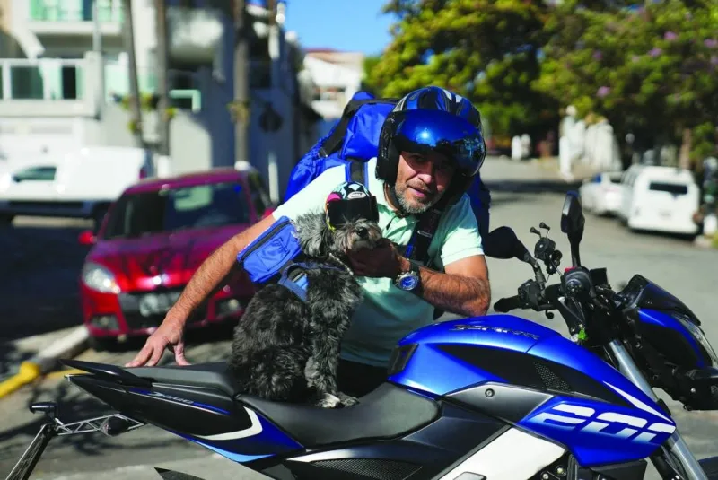 
Deliveryman Miguel Pereira and his rescued dog Ruby pose for a picture while making a delivery ride on a motorcycle, to donate food to stray dogs on the streets in Sao Paulo. 