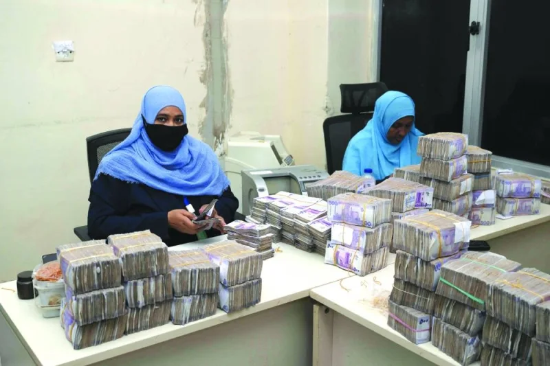 Employees count bills at the Central Bank in Port Sudan, on Sunday.