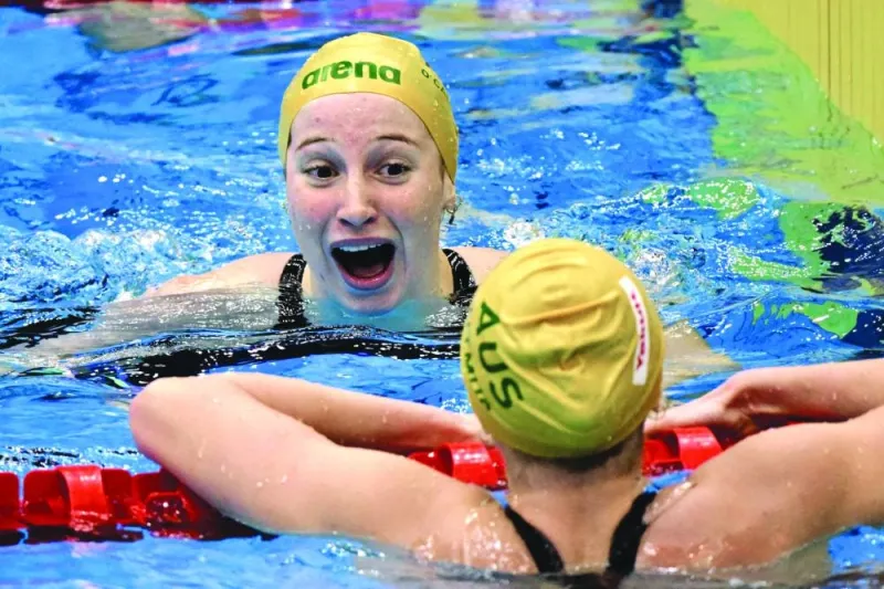 Australia’s Mollie O’Callaghan (top) celebrates with compatriot Ariarne Titmus after breaking the world record to win the women’s 200m freestyle gold at the World Aquatics Championships in Fukuoka, Japan, on Wednesday. (AFP)