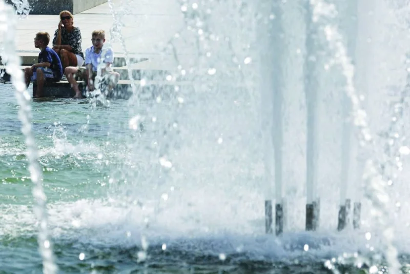 
Visitors cool themselves off at the fountain of the World War II Memorial in Washington, DC. 