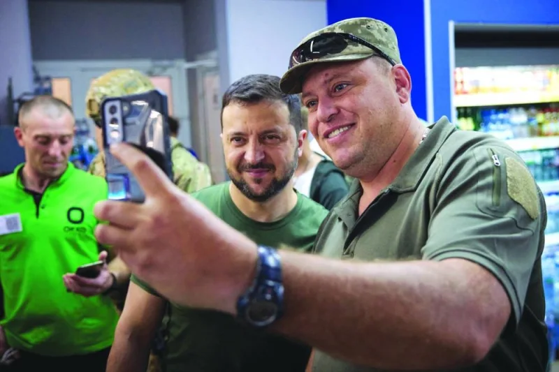 President Volodymyr Zelensky (L) posing for a picture with a serviceman during his visit to Donetsk region, Saturday.