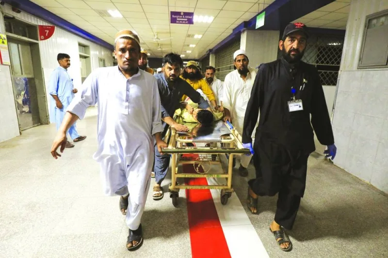 People transport a man, who was injured after a blast in Bajaur district of Khyber Pakhtunkhwa, at the Lady Reading Hospital in Peshawar on Sunday. (Reuters)