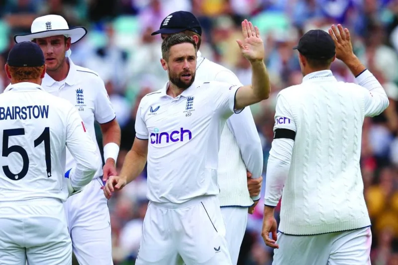 
England’s Chris Woakes celebrates with teammates after taking the wicket of Australia’s Usman Khawaja on day five of the fifth Ashes Test at the Oval in London on Tuesday. (AFP) 