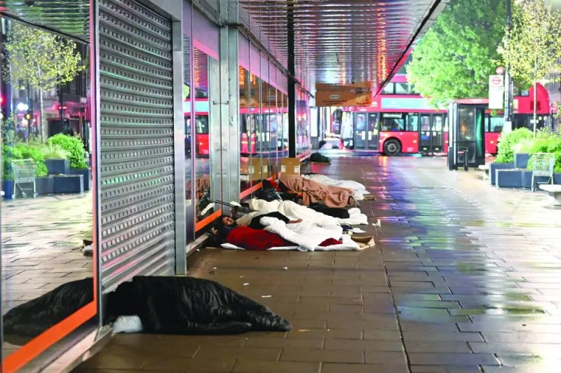 Rough sleepers in their makeshift beds outside closed shops on Oxford Street, at daybreak in London yesterday.
