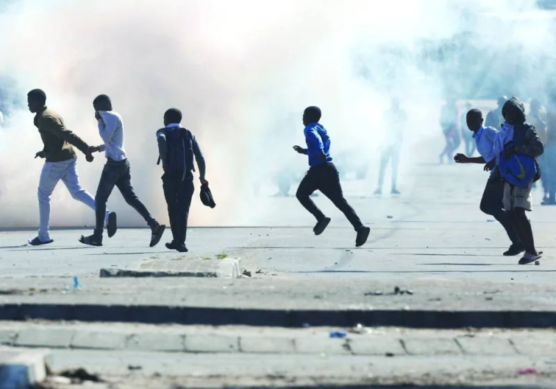 
Demonstrators run as tear gas is being sprayed during the ongoing strike by taxi operators against traffic authorities in Cape Town, South Africa. 