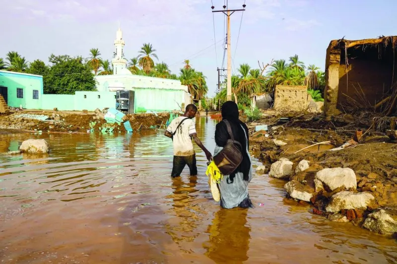 
People walk through a flooded area in Al-Sagai north of Omdurman. Torrential rains have destroyed more than 450 homes in Sudan’s north, validating concerns voiced by aid groups that the wet season would compound the war-torn country’s woes. 