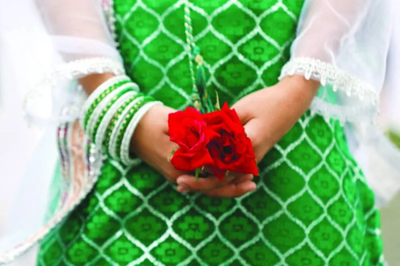 
A girl wears a dress and bangles with the colours of the Pakistani flag, (Reuters) 