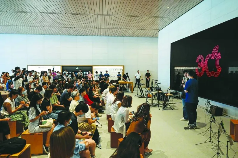 People attend an event celebrating Apple’s 30th anniversary in China at an Apple retail store in Beijing on Friday.