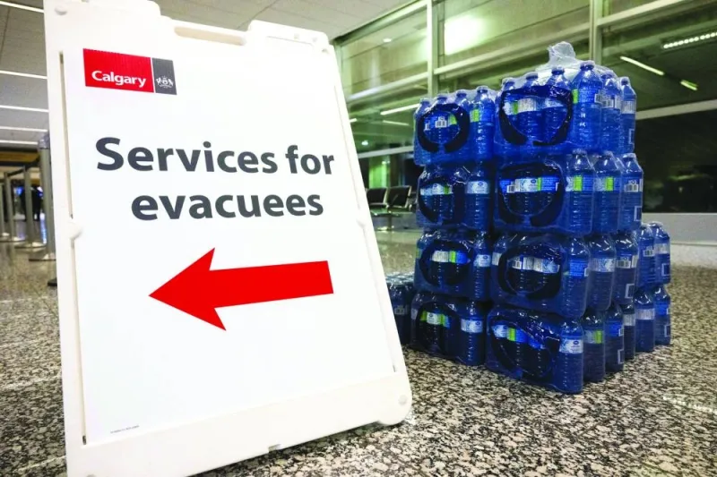
A sign for evacuee services is seen next to a pallet of bottled water at the Calgary Airport. 