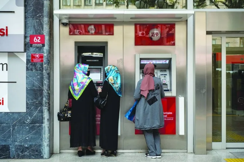 Customers use automatic teller machines in Ankara. Turkiye took a first step away from a tool designed to halt a sell-off in the lira by imposing a rule that banks must increase their government bond holdings if they don’t convince their clients to shift to regular deposits in the currency.