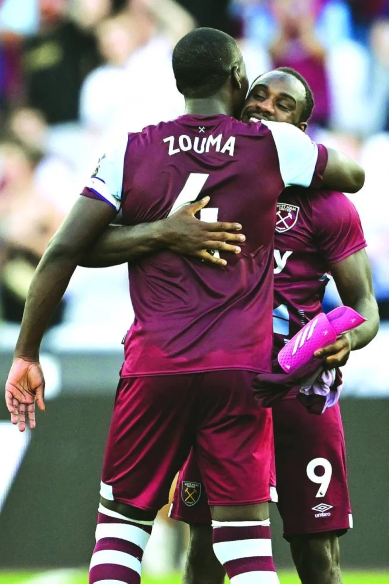 West Ham United’s midfielder Michail Antonio celebrates with teammate Kurt Zouma during their Premier League match against Chelsea in London on Sunday. (AFP)