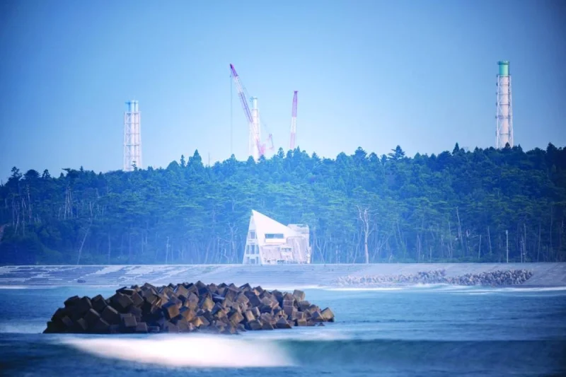 
Right: This long exposure picture shows a damaged house (front) with the facilities of Tokyo Electric Power Company Holdings (Tepco) Fukushima Daiichi nuclear power plant (back), seen from Ukedo fishing port in Namie, Fukushima prefecture. 