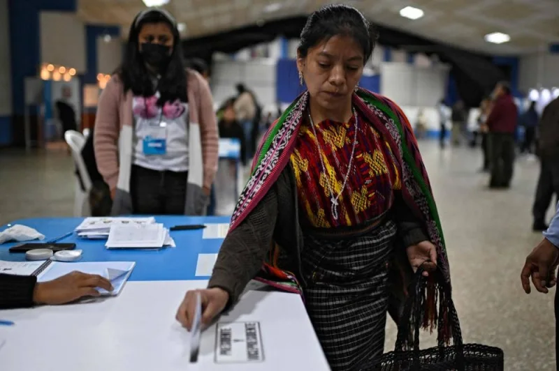 
A woman of the Q’eqchi Indigenous ethnic group casts her vote at a polling station in the municipality of San Juan Sacatepequez. 