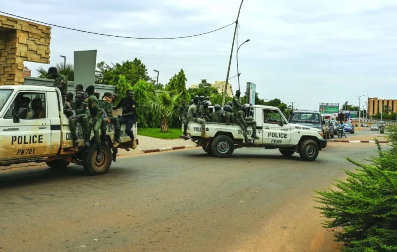 
Police officers ride on the back of a pick-up truck as they patrol in Niamey. 