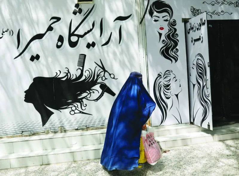 
An Afghan woman walks past a beauty salon in Kabul on July 6. (Reuters) 