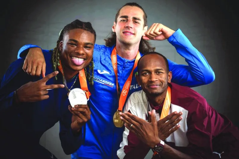 High jump silver-medallist USA’s JuVaughn Harrison (left), gold-medallist Italy’s Gianmarco Tamberi (centre) and bronze-medallist Qatar’s Mutaz Essa Barshim pose on the sidelines of the World Athletics Championships in Budapest on Wednesday. (AFP)