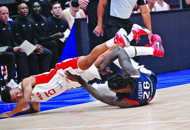 France’s Mathias Lessort (right) and Canada’s Trae Bell-Haynes fall as they vie for a ball during the FIBA Basketball World Cup, Group H match, at Indonesia Arena in Jakarta on Friday. (AFP)