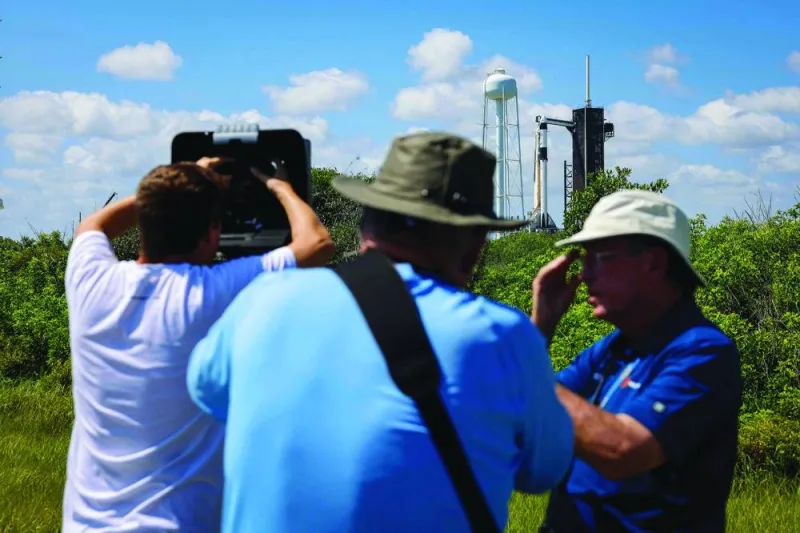 
Photographers reset remote cameras to capture images of SpaceX Falcon 9 rocket and Dragon spacecraft after its launch was scrubbed at the Kennedy Space Centre in Cape Canaveral, Florida. 