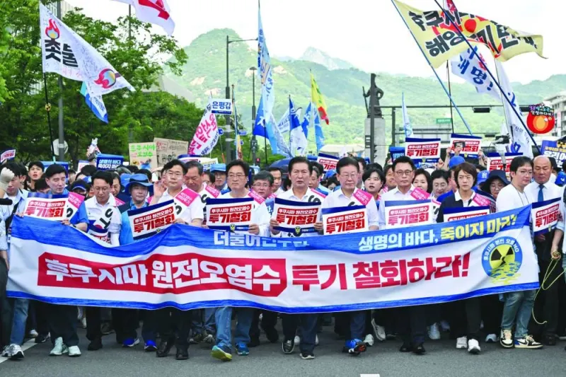 South Korea’s main opposition Democratic Party lawmakers and party members march with a banner reading “Stop dumping Fukushima nuclear contaminated water into the ocean!” during a rally against Japan’s discharge of treated wastewater from the crippled Fukushima nuclear power plant, at Gwanghwamun Square in Seoul on Friday.