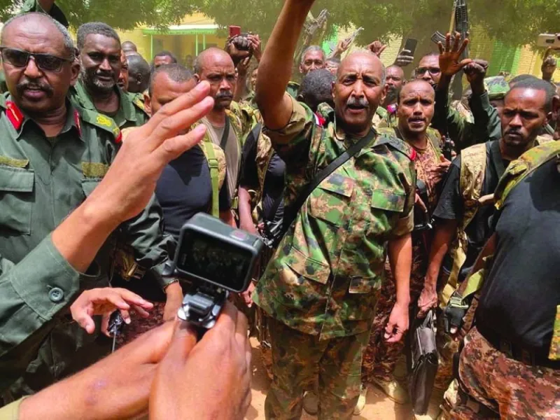 
Sudan’s General Abdel Fattah al-Burhan stands among troops in an unknown location,last May. (Reuters) 