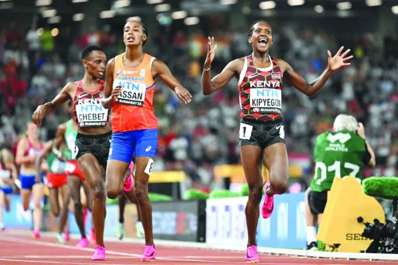 Kenya’s Faith Kipyegon reacts as she crosses the finish line ahead of Netherlands’ Sifan Hassan to win the women’s 5,000m final during the World Athletics Championships in Budapest on Saturday. (AFP)