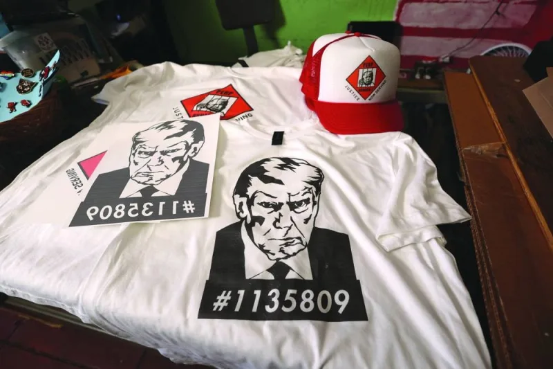 
T-shirts and hats with an image depicting the mugshot of former president Donald Trump are pictured at the Y-Que printing store in Los Angeles. 