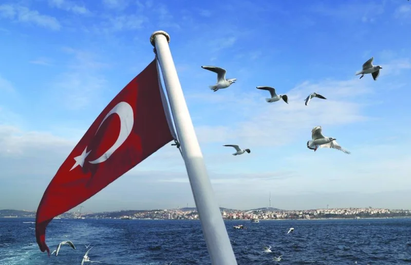 
A Turkish flag flutters on a passenger ferry with the Bosphorus in the background in Istanbul. On a quarterly basis, gross domestic product (GDP) expanded 3.5% on a seasonally and calendar-adjusted basis, also outstripping forecasts, Turkish Statistical Institute data showed. 