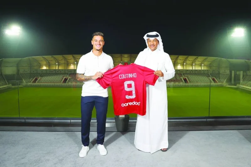 Philippe Coutinho poses with Al Duhail’s jersey and club’s vice-president Khalifa Khamis on Friday.