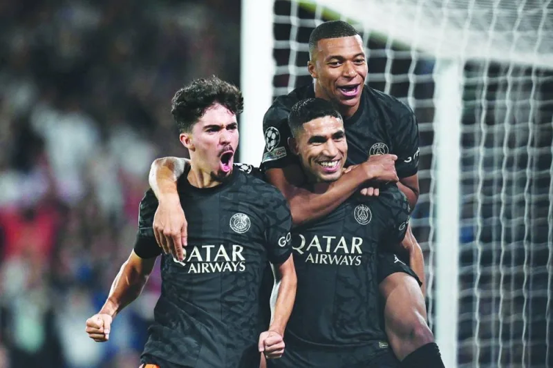 Paris Saint-Germain’s defender Achraf Hakimi (centre) celebrates with teammates Kylian Mbappe (right) and Vitinha after scoring a goal during the UEFA Champions League Group F match against Borussia Dortmund at Parc des Princes stadium in Paris on Wednesday. (AFP)
