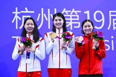 
Silver-medallist China’s Yu Liyan (left), gold-medallist China’s Zhang Yufei (centre) and bronze-medallist Japan’s Hiroko Makino celebrate during women’s 200m butterfly medals ceremony at the Asian Games in Hangzhou yesterday. (AFP) 