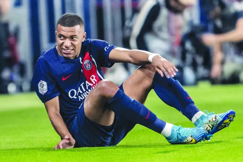 Paris Saint-Germain’s French forward Kylian Mbappe grimaces as he sits on the pitch during the French L1 match against Olympique de Marseille at The Parc des Princes Stadium in Paris on Sunday. The France international was eventually replaced just after the half-hour mark. (AFP)